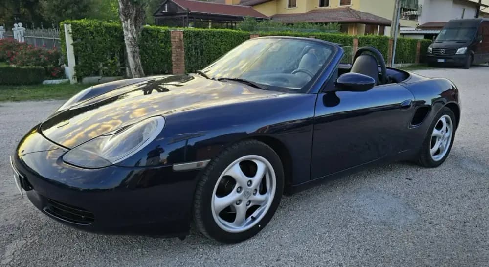 Porsche Boxster 986 blu con la capote aperta, vista di profilo