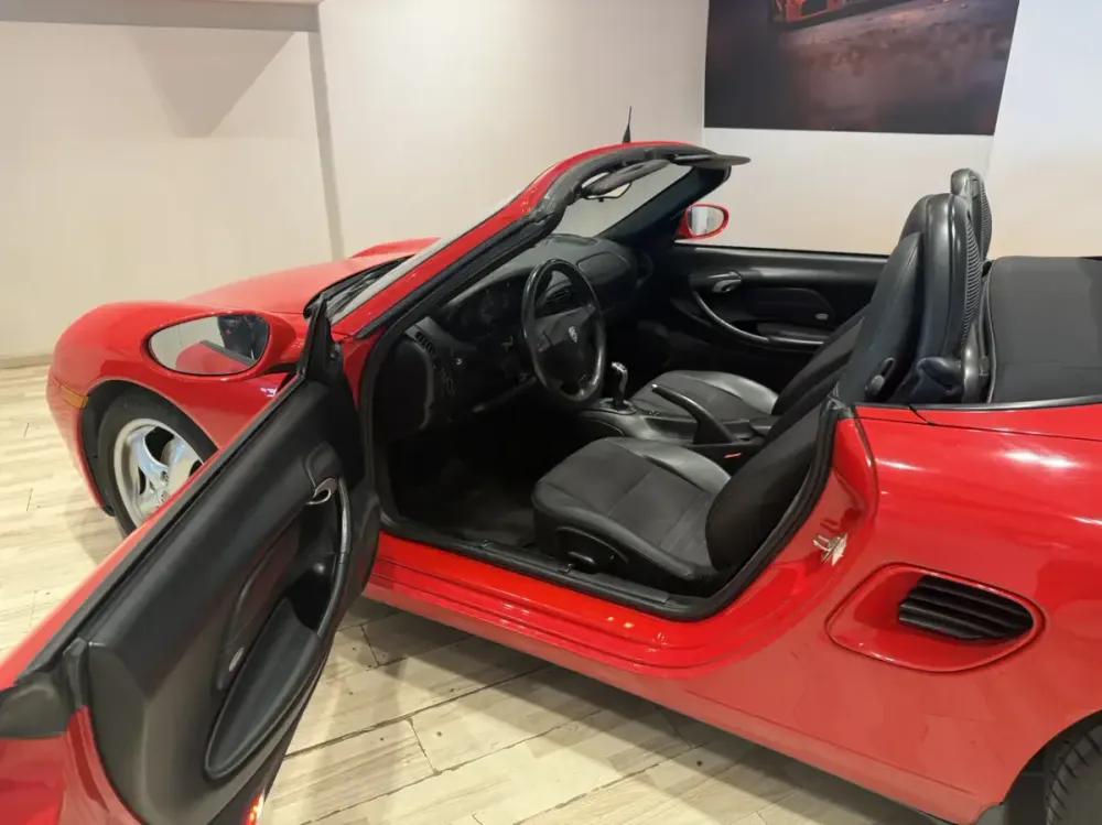 Abitacolo di una Porsche Boxster 986 rossa con la capote aperta