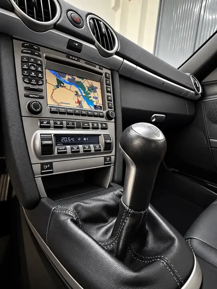 Consolle centrale di una Porsche Cayman 987 con leva del cambio e navigatore